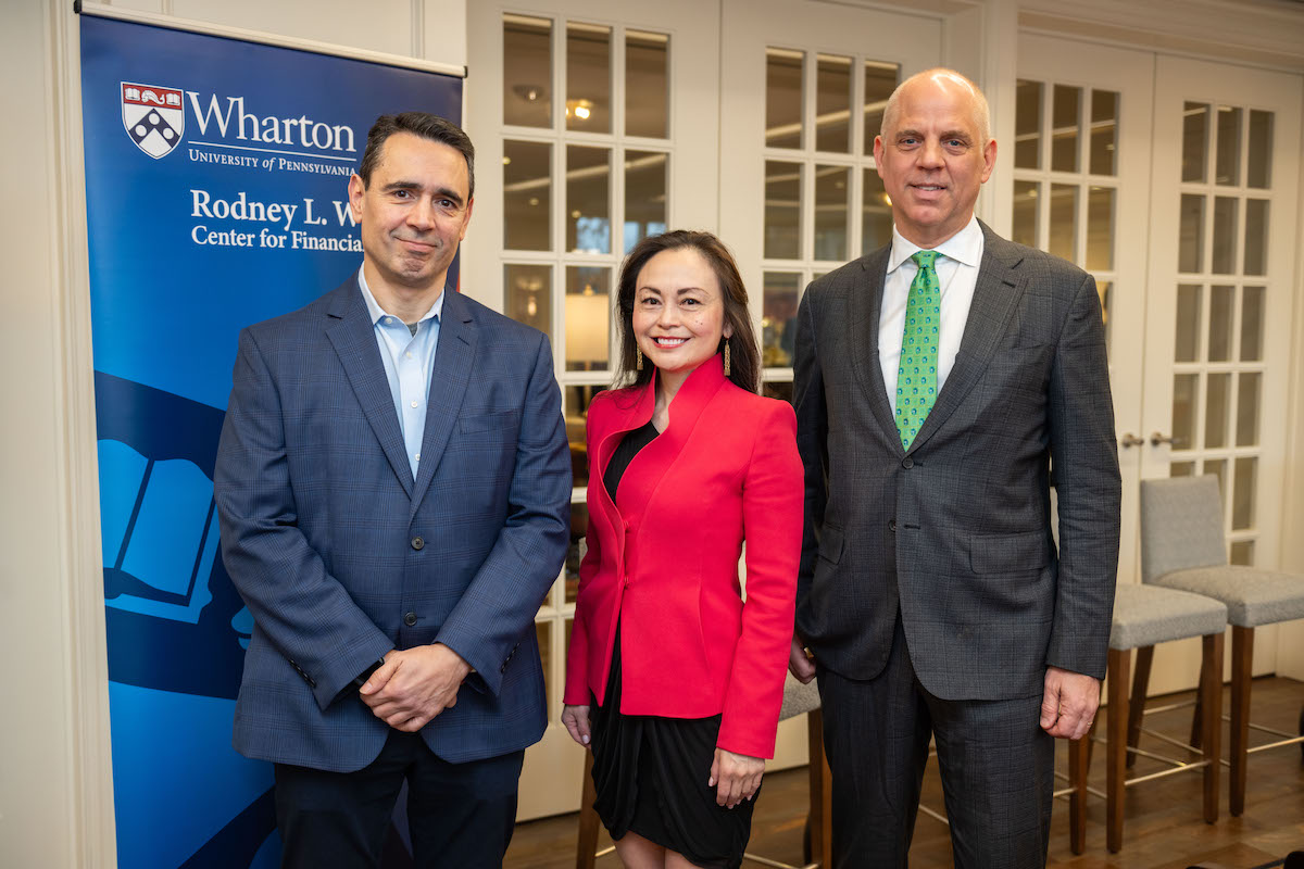 Joao Gomes, Sarah Hammer, and David Musto pose for a photo before a Rodney White Center banner