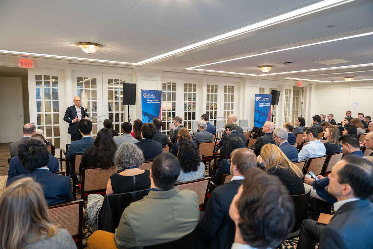 A speaker at a panel before an audience