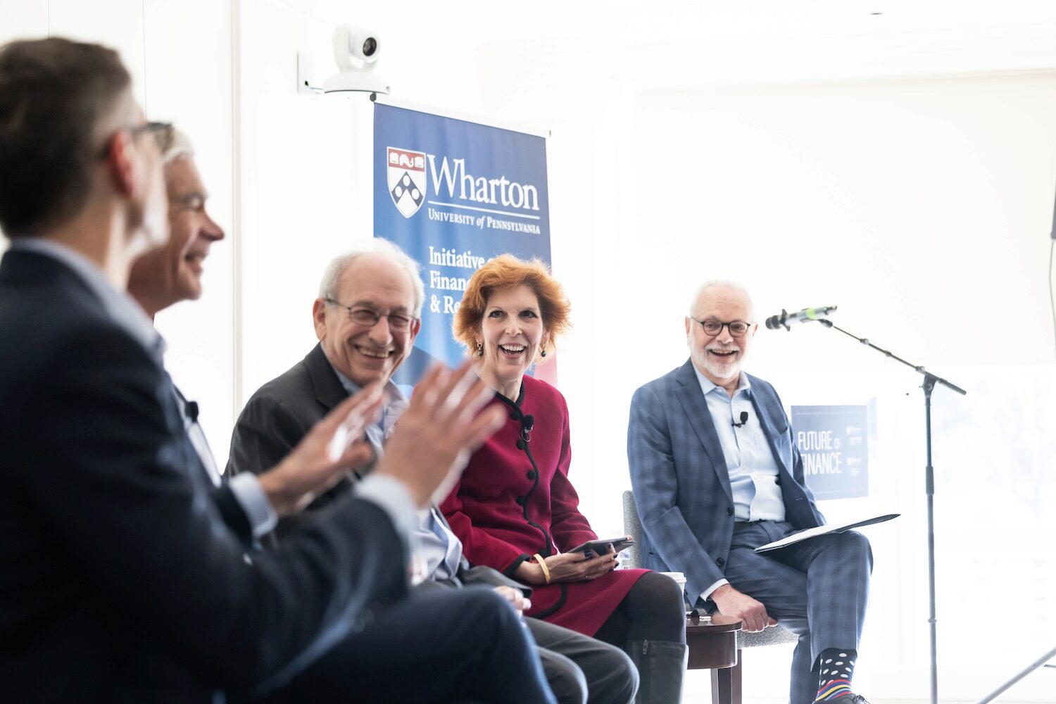 Panelists smiling while speaking in a sunlit room