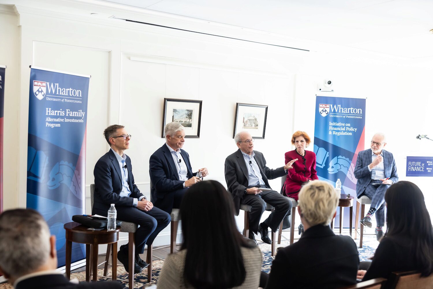 Five panelists at a conference in conversation