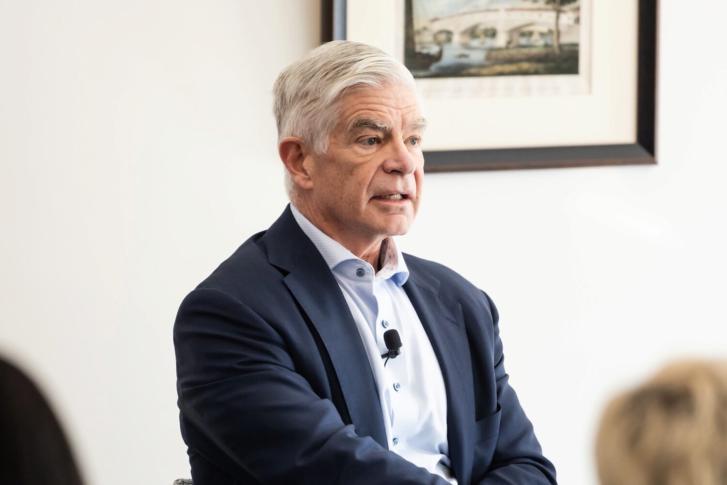 A conference speaker seated before an audience