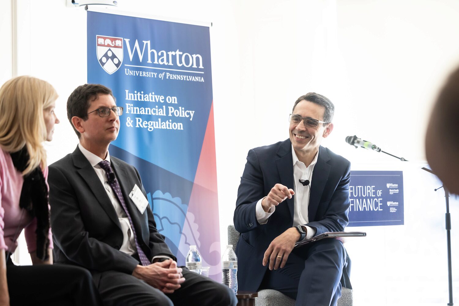 Three conference speakers smiling while in conversation