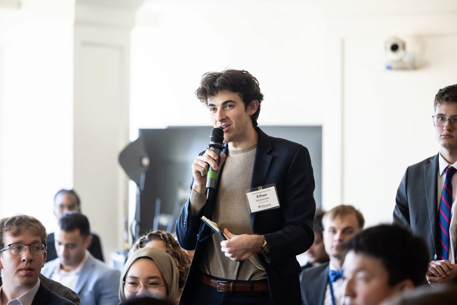 A conference audience member asks a question into a microphone