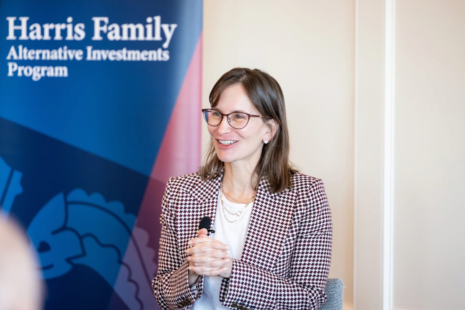 A speaker at a conference smiles to the audience